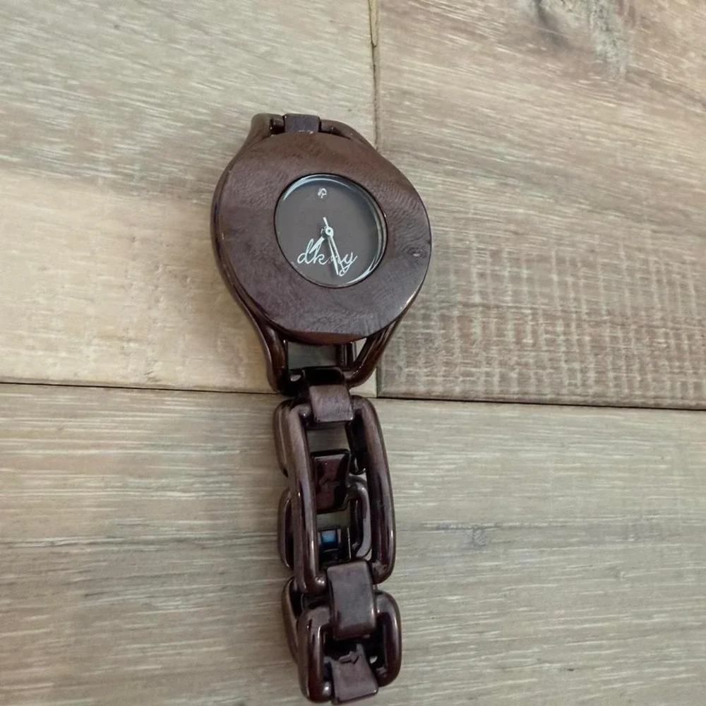 brown DKNY wristwatch featuring a distinct oval case and chain-link bracelet